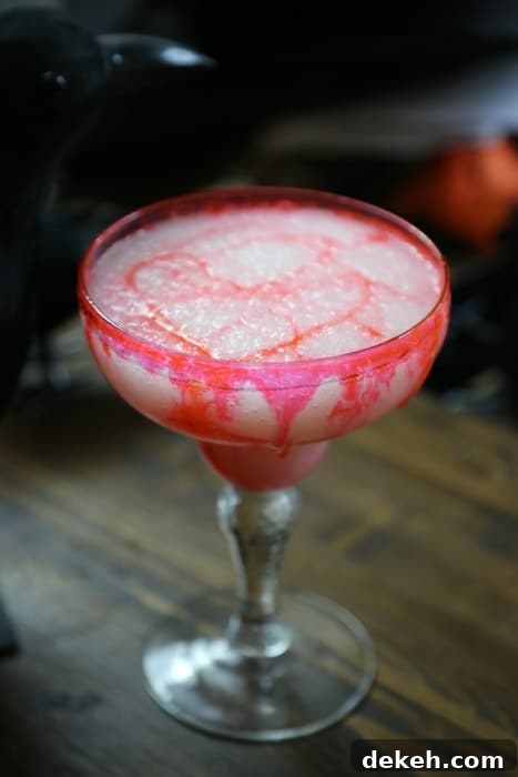 Bloody colada drink in a margarita glass with a crow behind it 