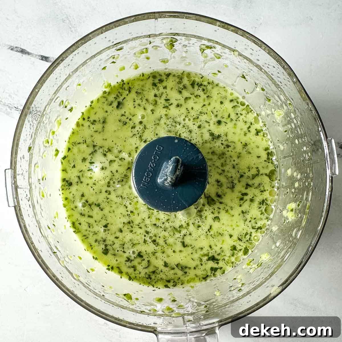 The blended vinaigrette is shown in a mini food processor.