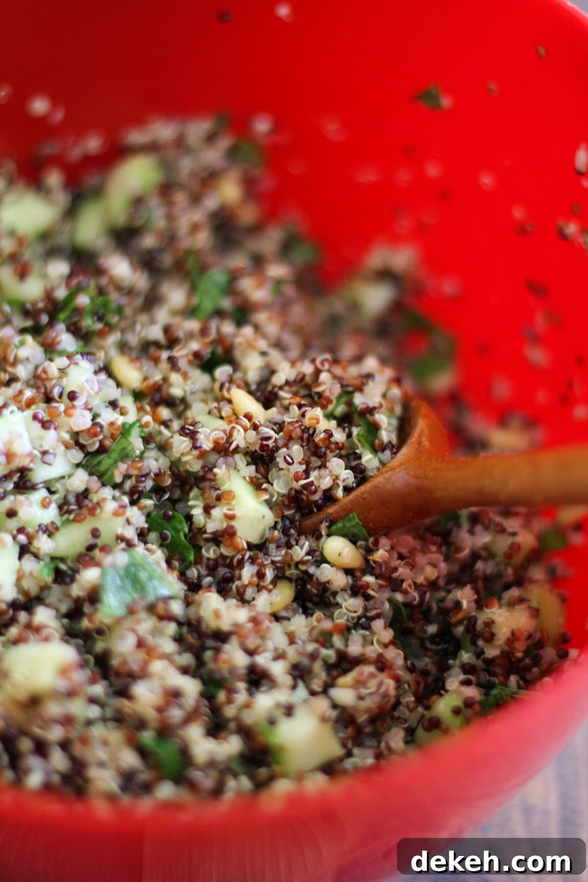large mixing bowl full of prepared quinoa salad, ready to eat.