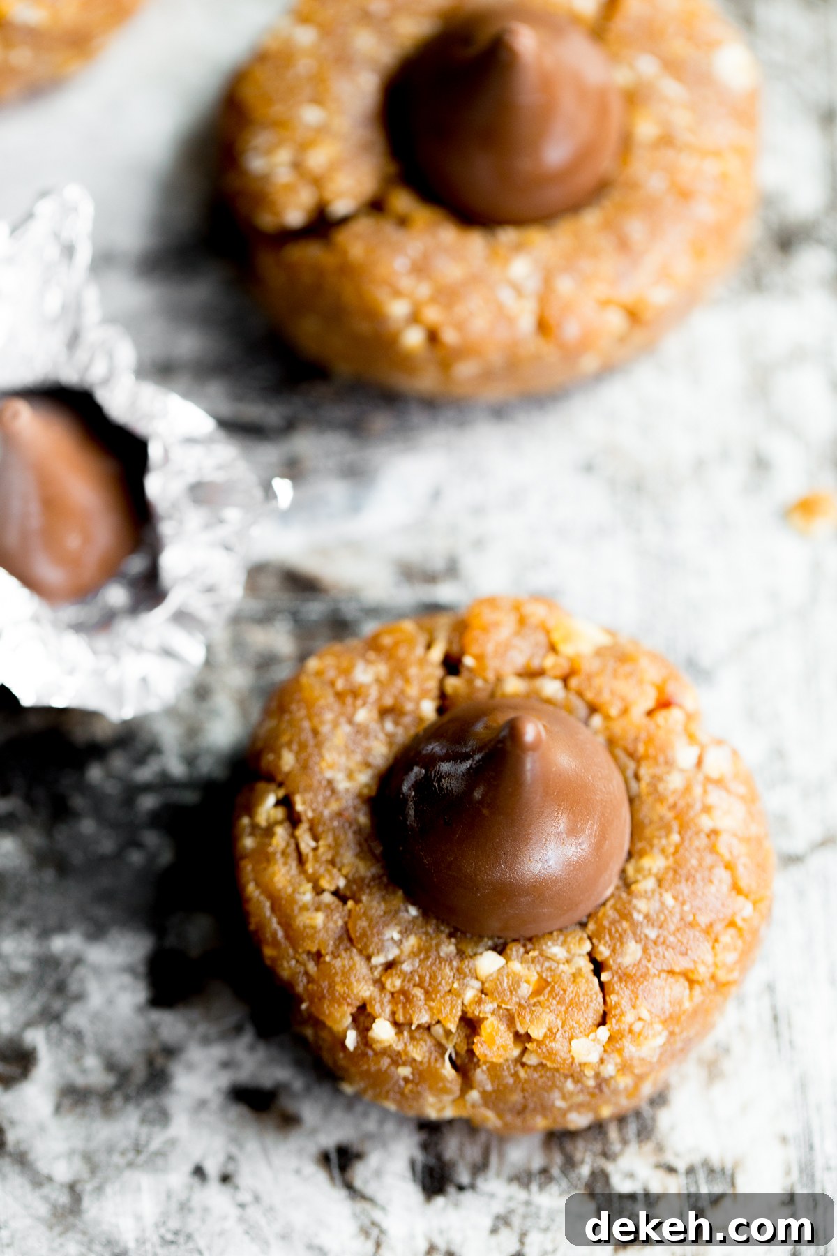 close up photo of healthy peanut butter kiss cookie on sheet pan with title text overlay