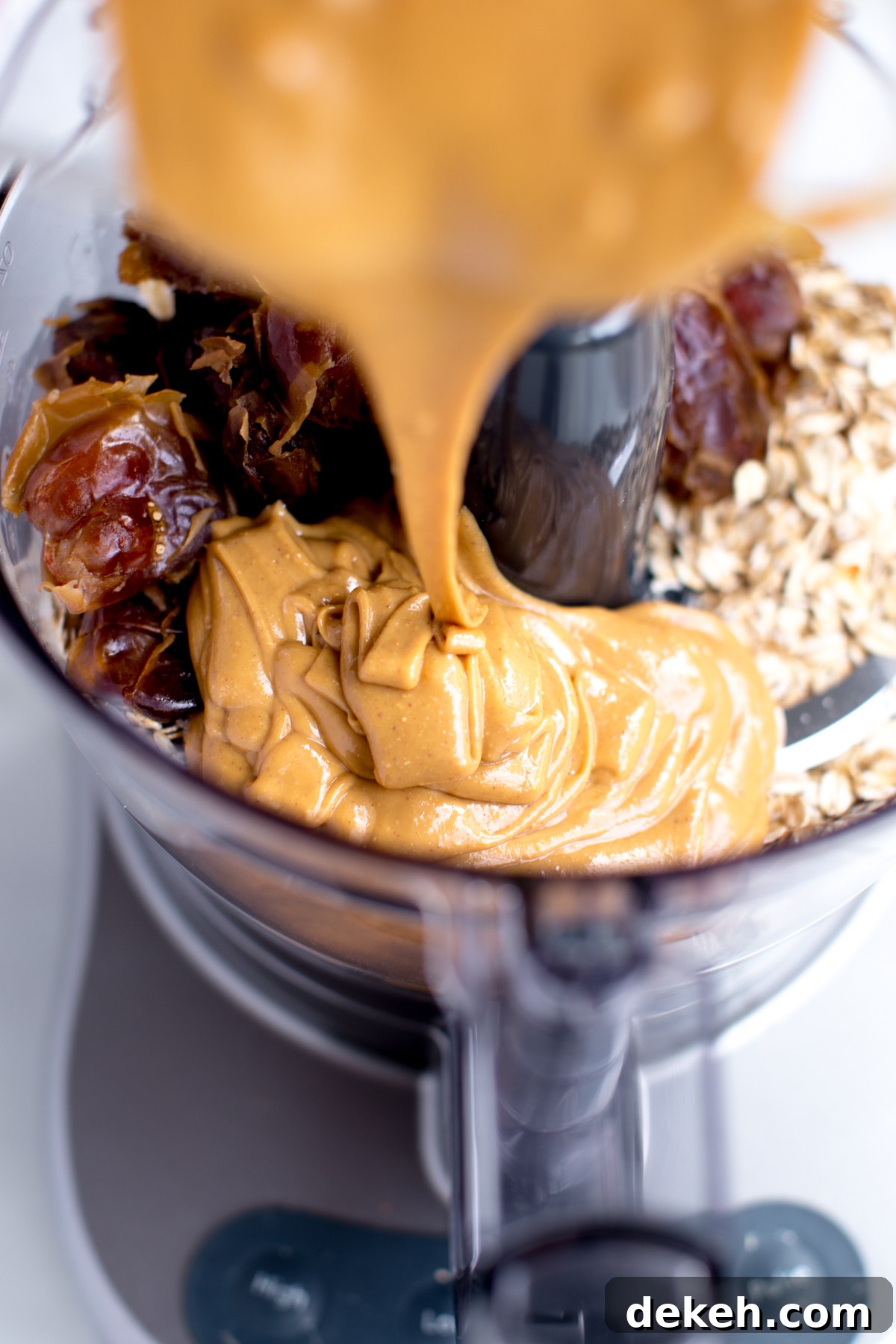ingredients for no-bake peanut butter snack bite cookie dough in food processor with peanut butter drizzle