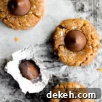 overhead photo of no bake peanut butter hershey's kiss cookies on sheet pan next to hershey's kiss in wrapper