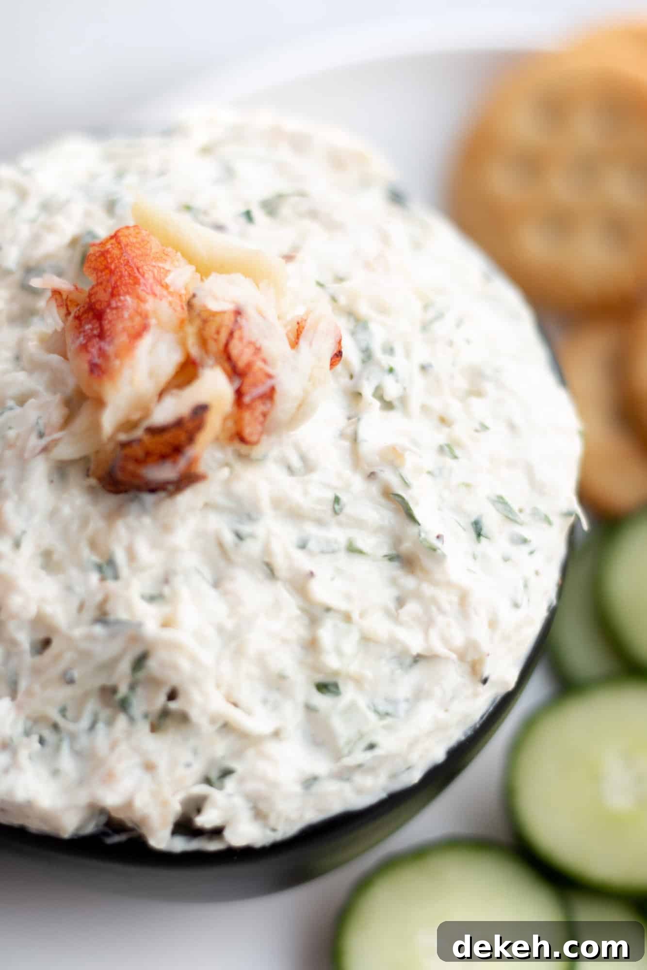 Creamy Chilled Crab Dip Recipe for Parties and Appetizers 2 A plate with a bowl of fresh crab dip, ritz and cucumber slices.