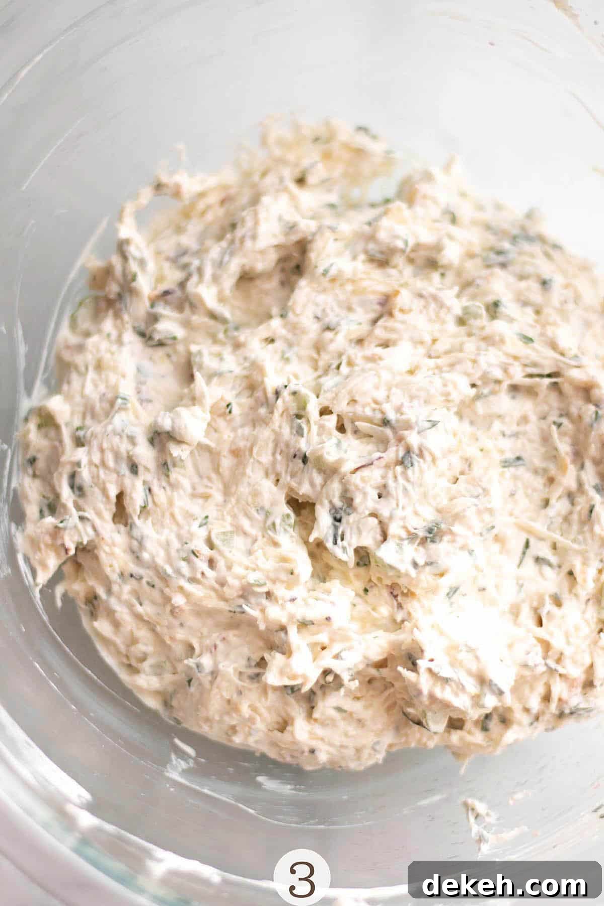 Creamy Chilled Crab Dip Recipe for Parties and Appetizers 5 A glass bowl with cream cheese, sour cream and fresh crab mixed in.