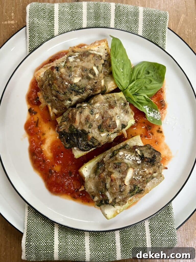 Three pieces of Baked Stuffed Cucuzza Squash over tomato sauce on white plate with basil sprig garnish.