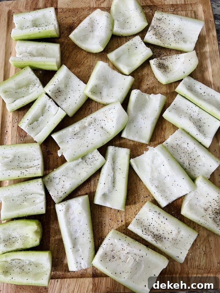 Prepped and seasoned squash ready to be stuffed on a cutting board.