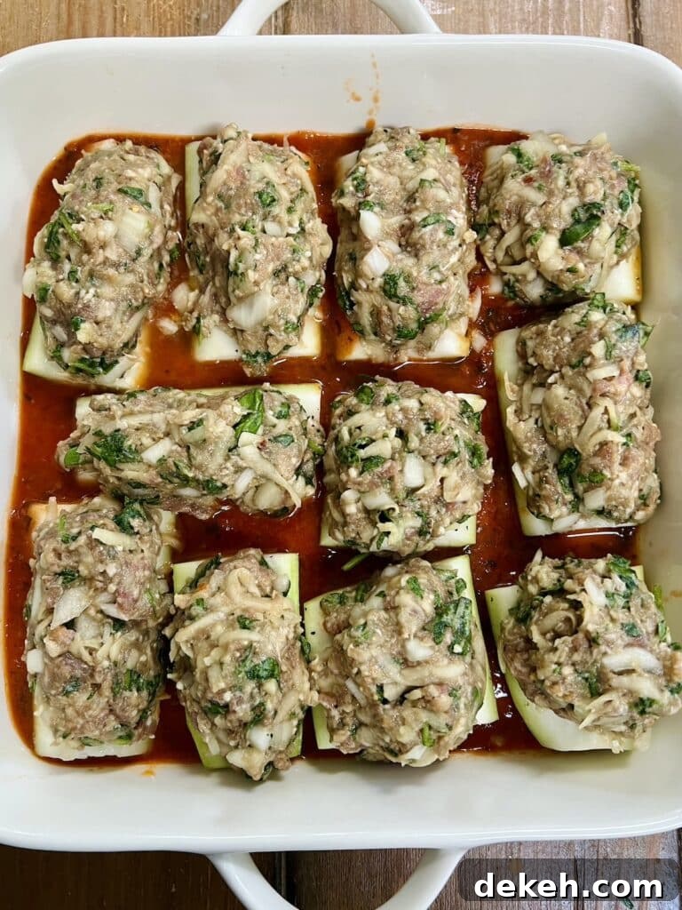 Stuffed cucuzza squash in white baking dish ready to bake.