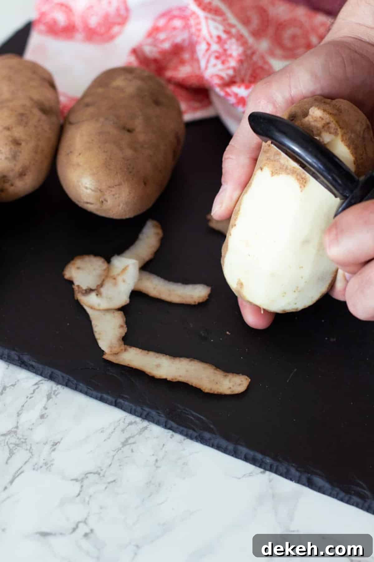 Person peeling a potato with peeler