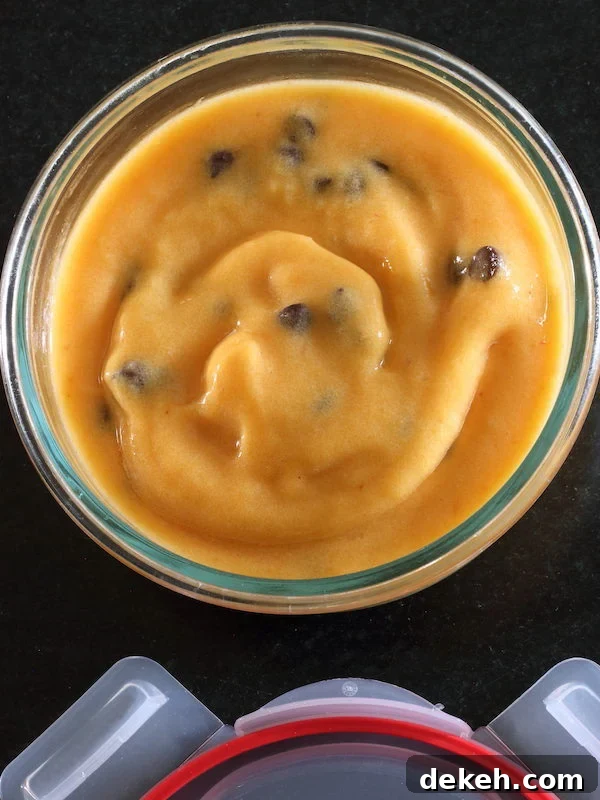 Peach dairy-free sorbet with chocolate chips in a round Pyrex bowl with snap on lid