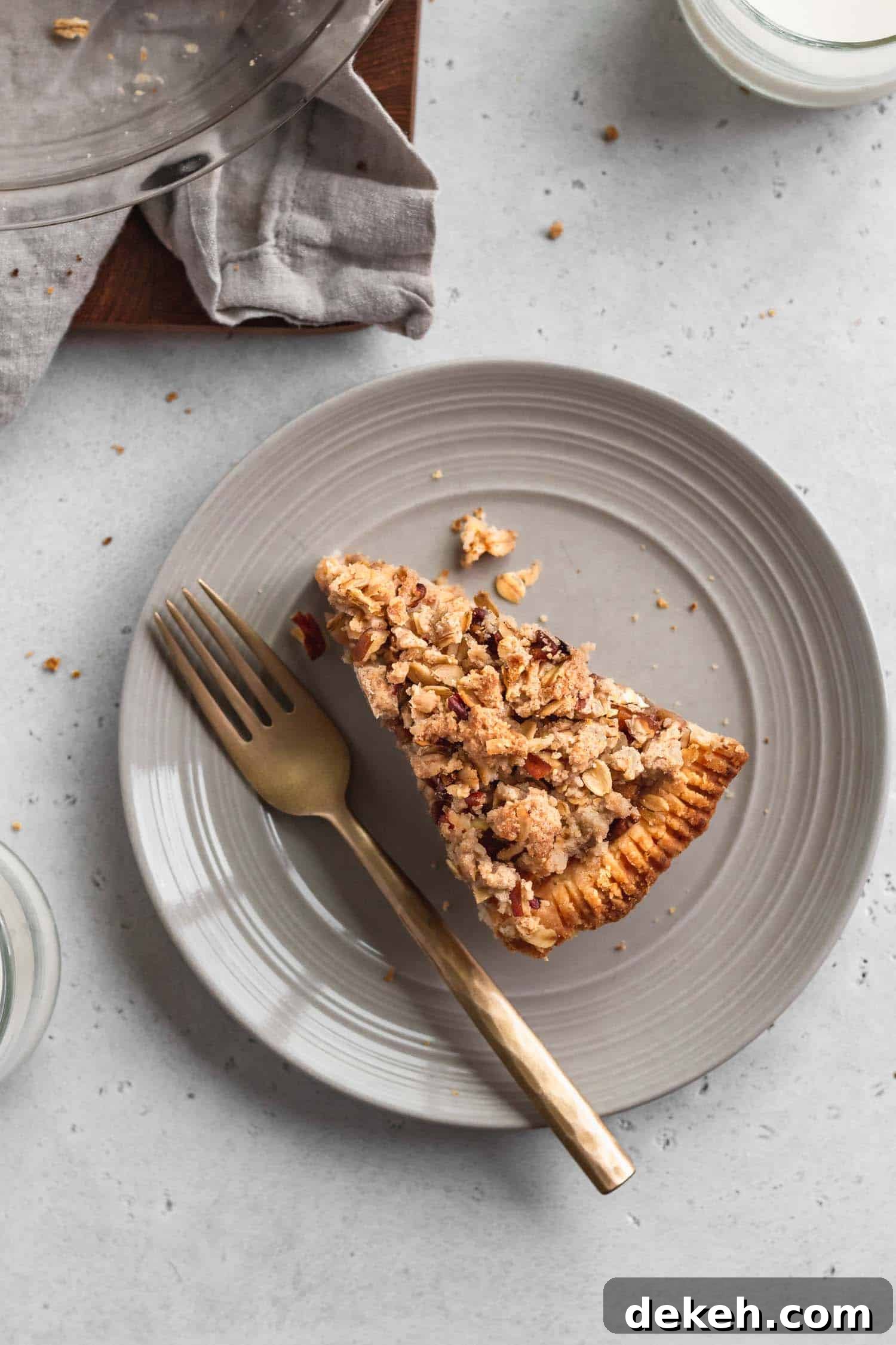 A slice of pie on a plate with a golden fork