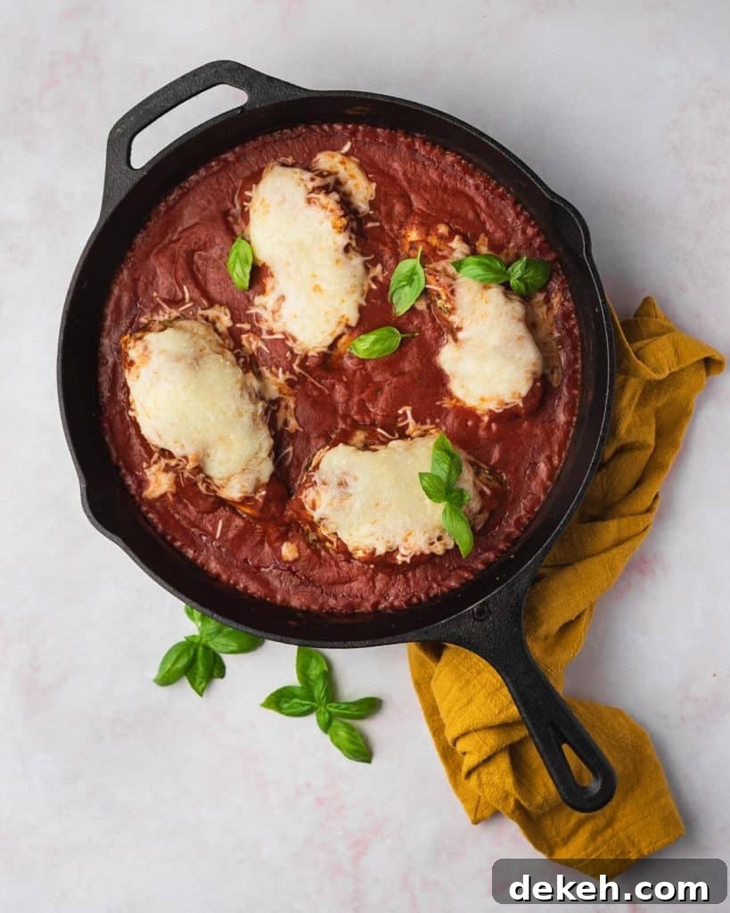 Mozzarella chicken in a cast iron with fresh basil.