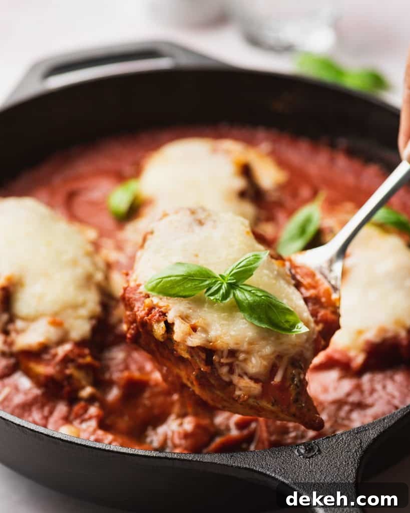 Mozzarella chicken being lifted from a pan.