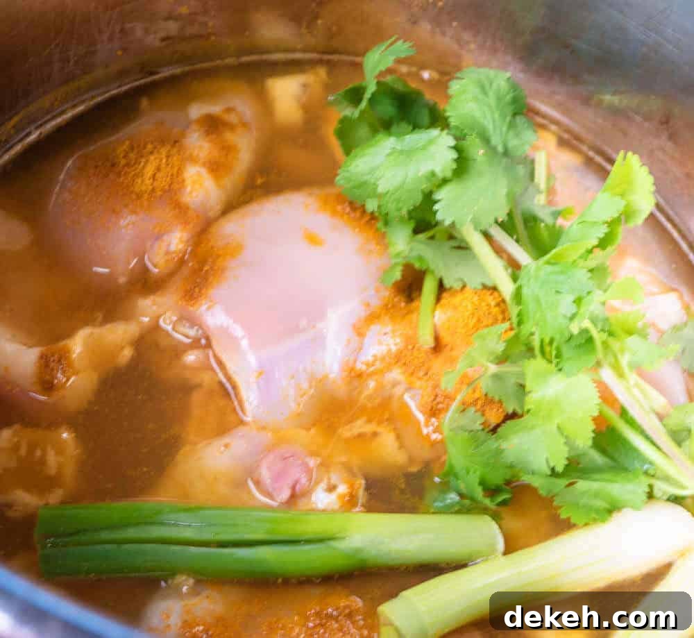 Instant Pot full of ingredients to cook some chicken curry