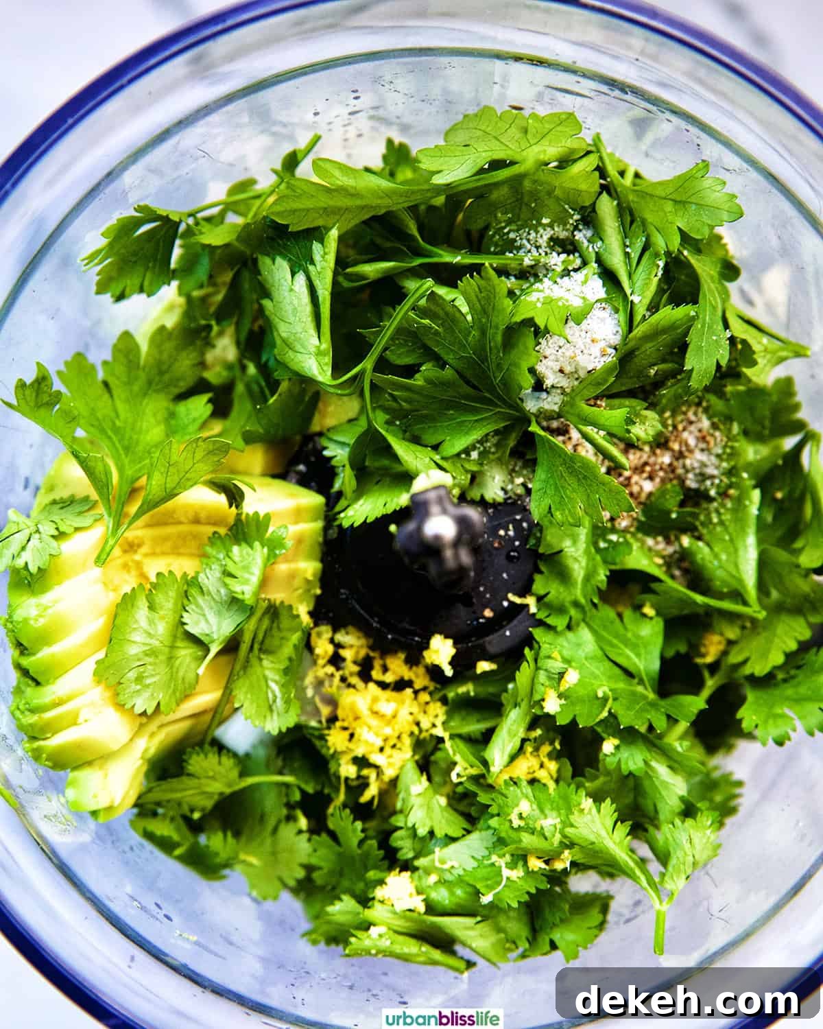 herbs, garlic, and other ingredients to make vegan green goddess dressing in a food processor.