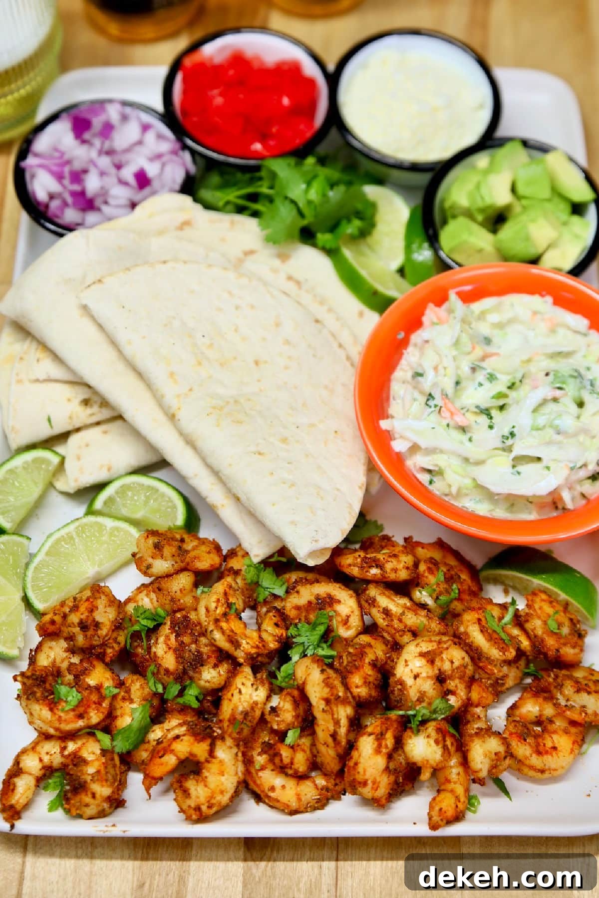Platter of shrimp, toppings and flour tortillas. 