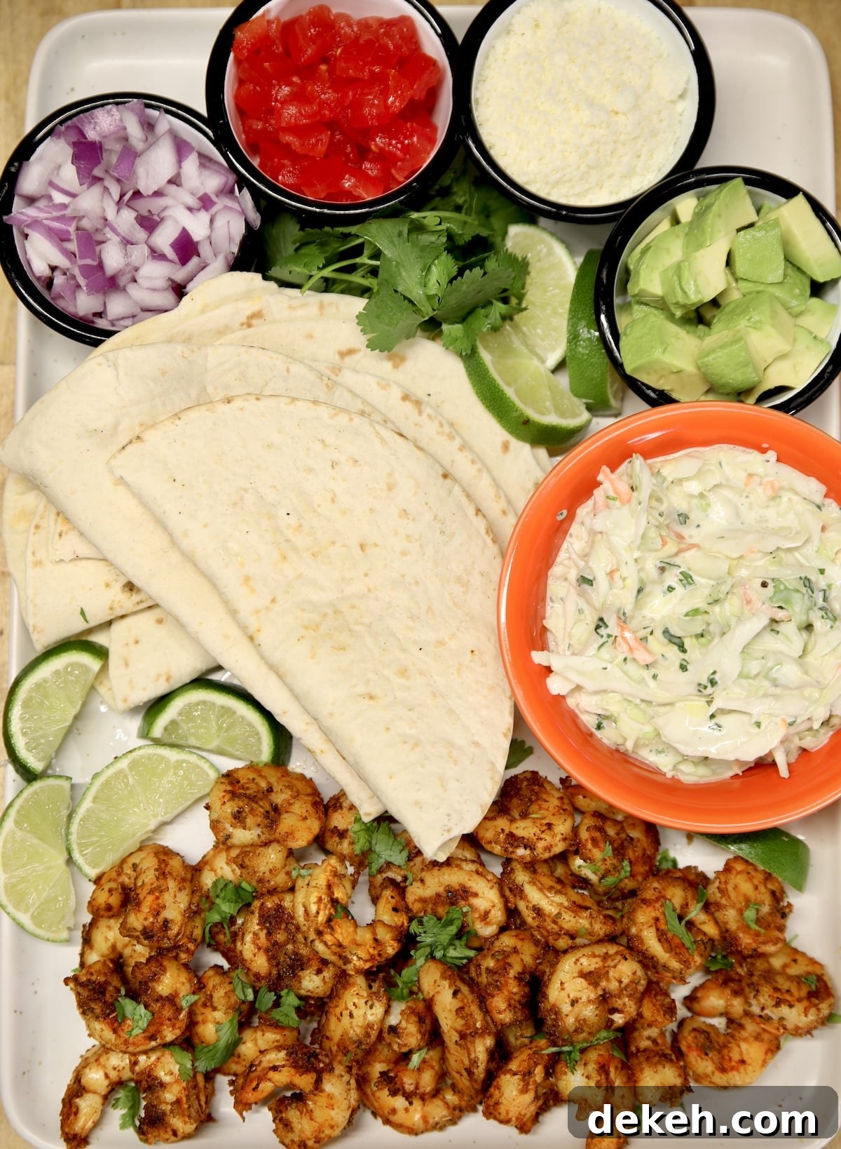 Platter with grilled shrimp, toppings and flour tortillas.