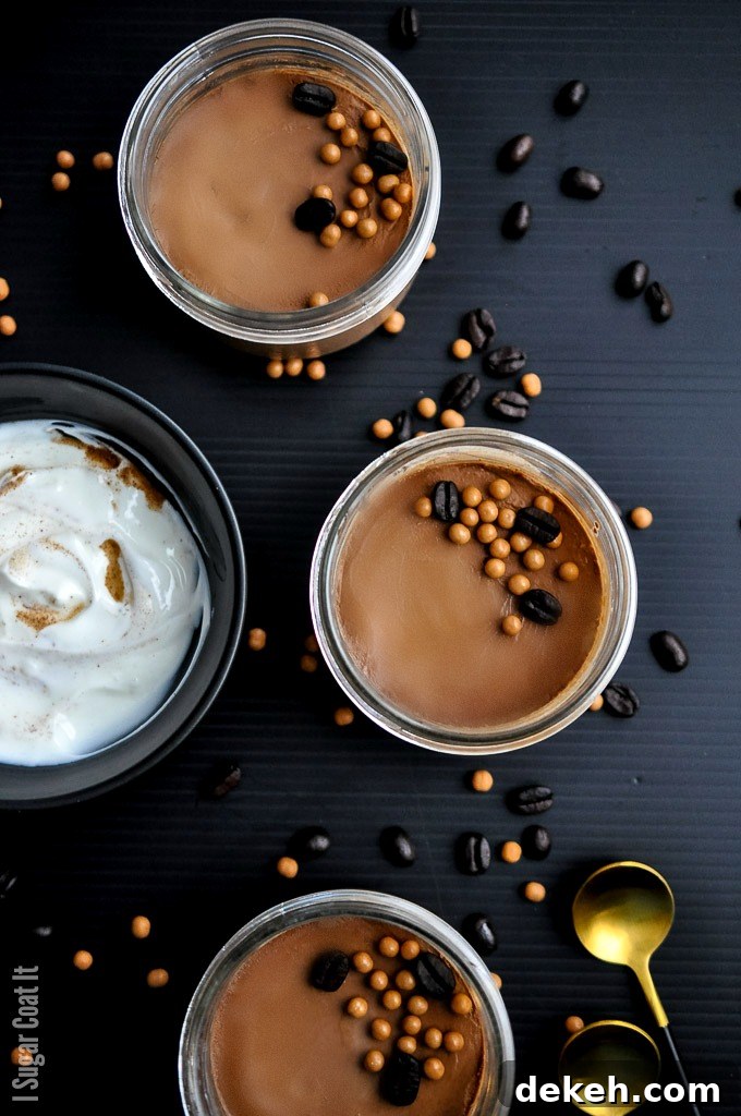 Jars of sous vide chocolate coffee pots de creme, with chocolate coffee beans and crisp pearls on a black background. | i sugar coat it