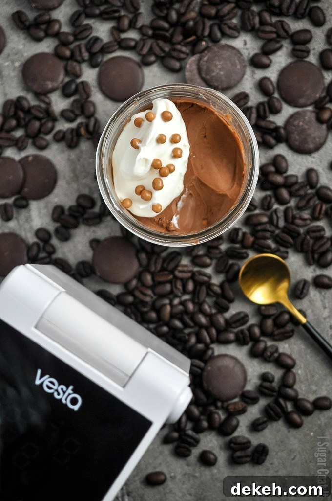 Jar of chocolate coffee pots de creme, topped with whipped cream and crisp pearls, nestled on a bed of chocolate and coffee, featuring Vesta Precision Imersa Elite sous vide cooker | I Sugar Coat It