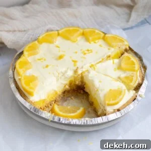 lemon pie with a slice cut out garnished with lemons