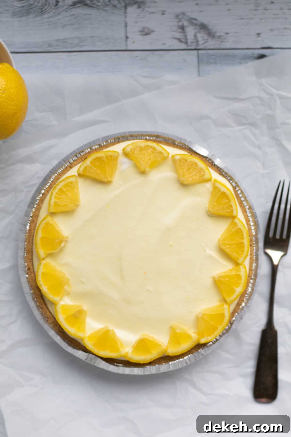whole lemon pie garnished with lemon wedges