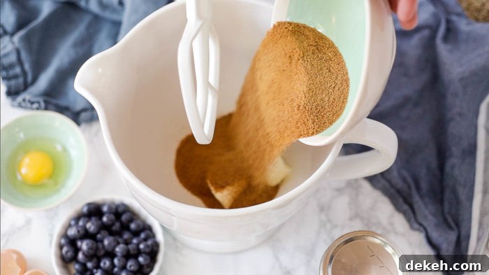coconut sugar being added to soften butter in a stand mixer
