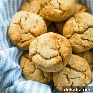 A batch of almond flour biscuits in a basket lined with a blue striped tea towel.