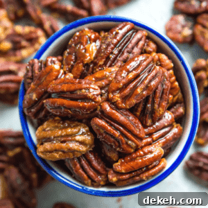 A bowl of honey glazed pecans, surrounded by more pecans.