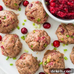 A plate with cranberry turkey meatballs on it with a bowl of cranberry sauce beside the meatballs.