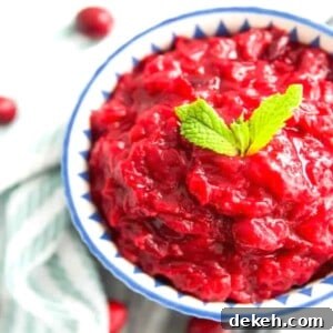 A bowl of sugar free cranberry sauce with mint leaves on top for garnish.