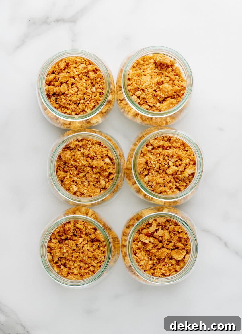 graham cracker crumbs in six glass jars arranged in two rows