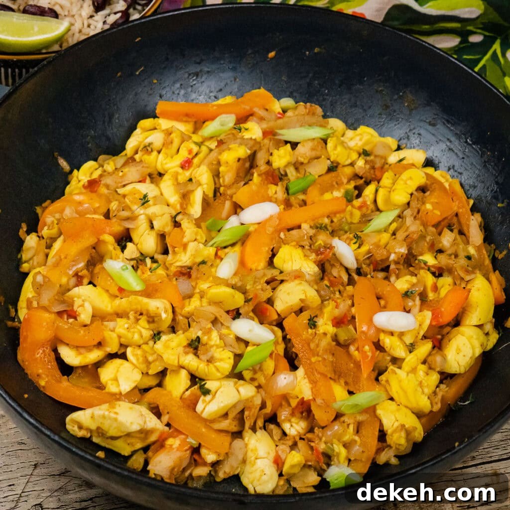 Ackee and Saltfish in a cast iron pan with chopped fresh spring onion sprinkled over the top