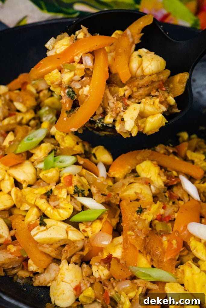 Ackee and Saltfish being scooped up with a ladle to serve