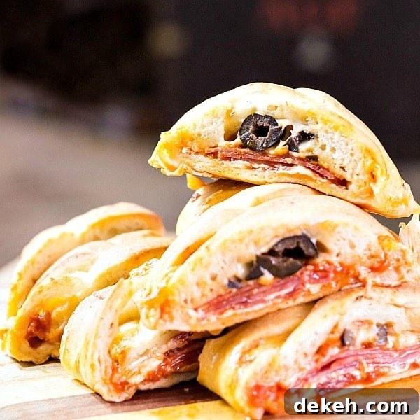 Cut open pizza bread showing the olives, cheese and pepperoni filling.