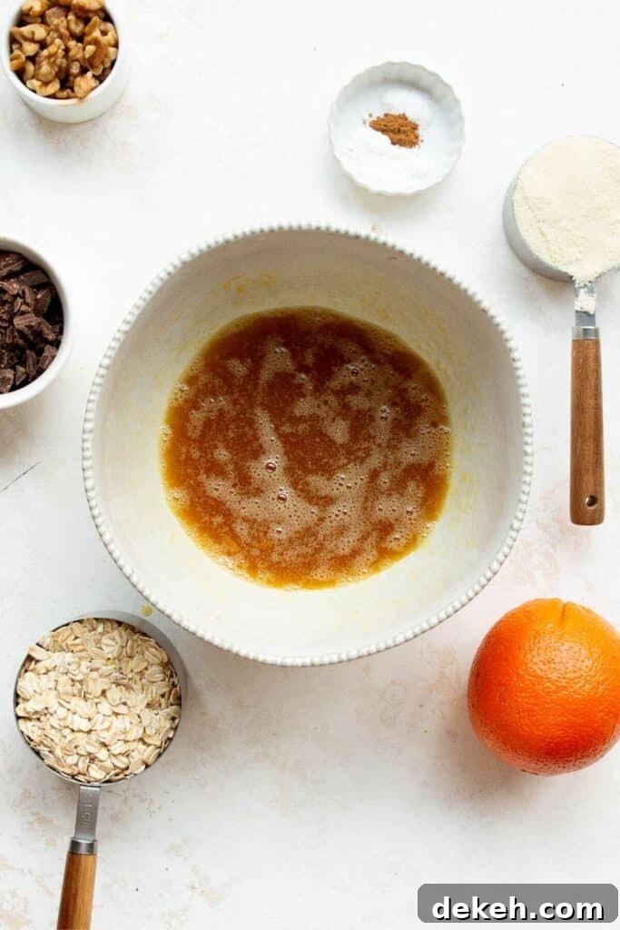 whisking together egg, maple syrup, melted coconut oil, and vanilla extract in a bowl