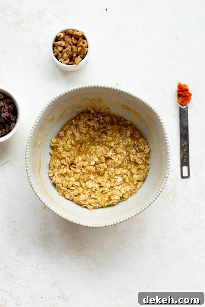 adding rolled oats, almond flour, baking powder, ground cinnamon, and salt to the same bowl with the wet ingredients