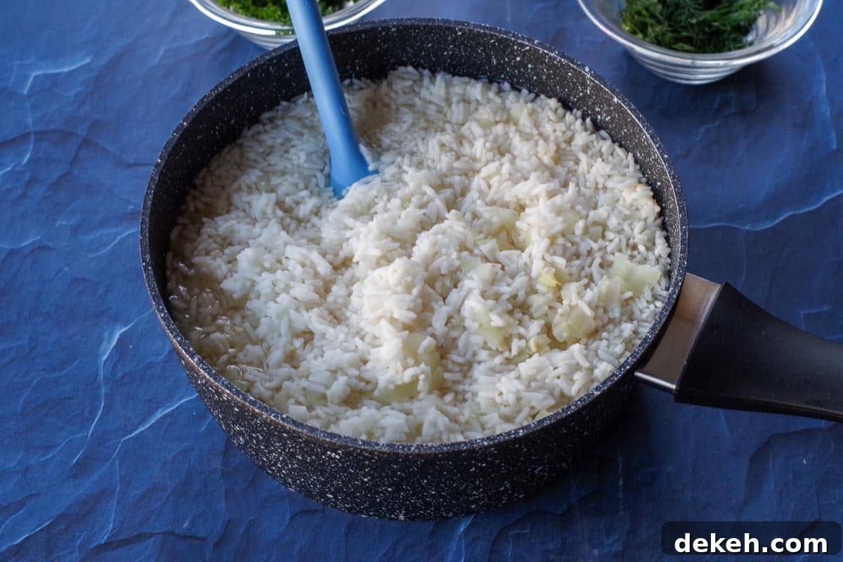 rice with broth, lemon juice, garlic and onion in a black pot