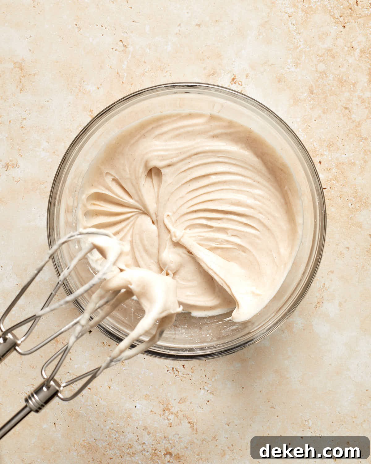 Cinnamon cream cheese frosting in a glass bowl.