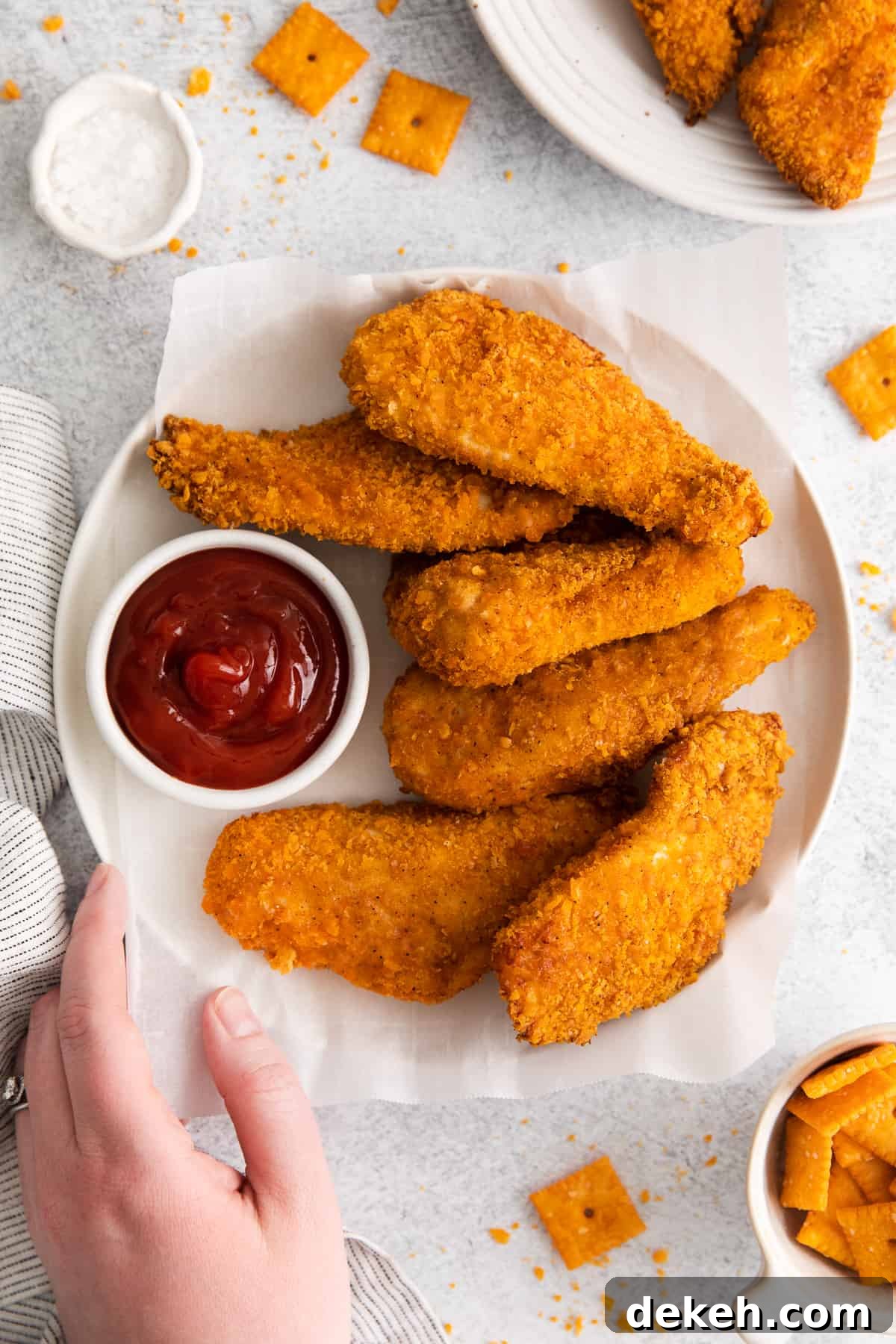 Chicken fingers on a plate with ketchup.