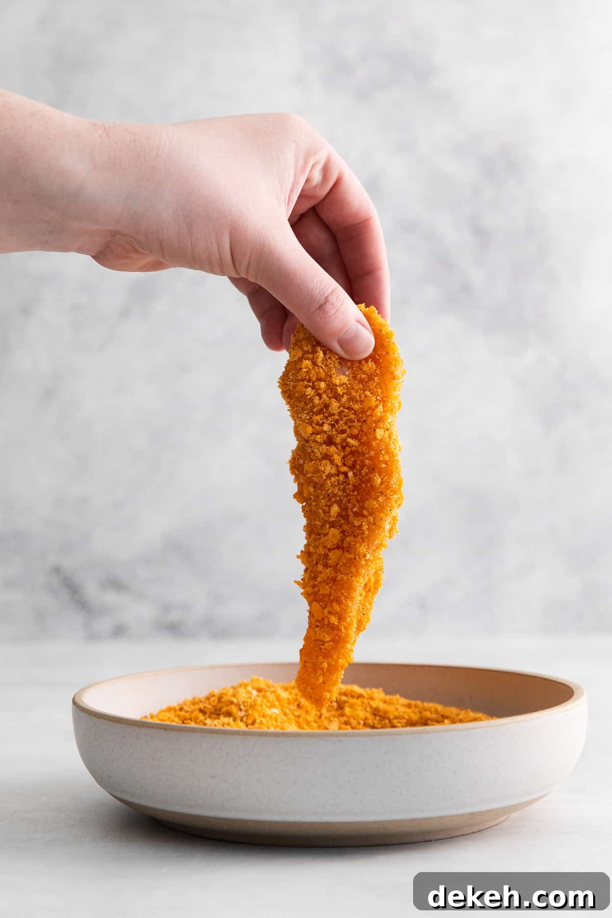 Raw chicken finger dipped in a cheez it breading.