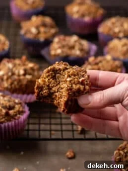 hand holding a wonderfully wholesome date muffin with a bite taken out