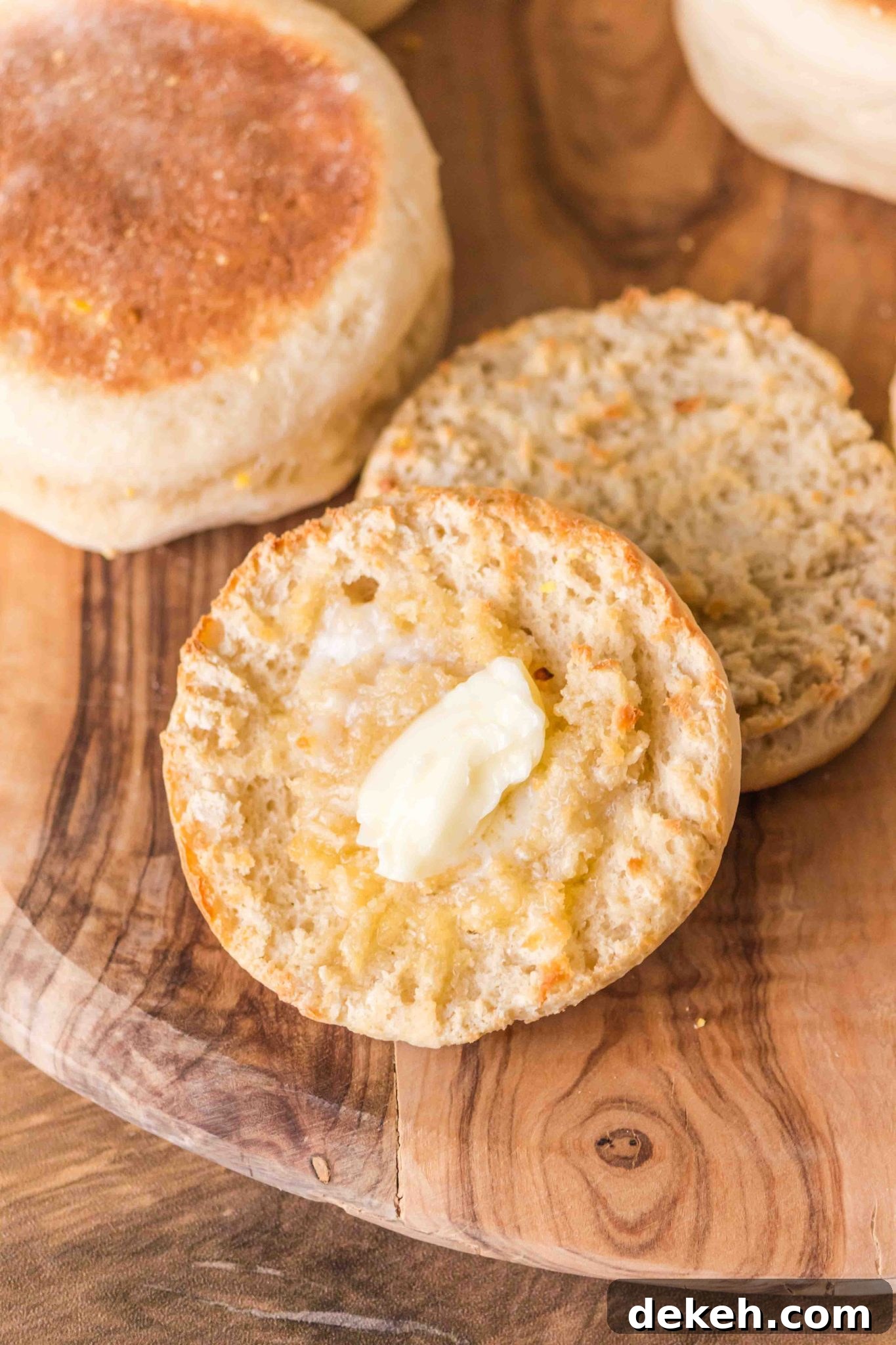 Top down view of a split English Muffin with a pad of melting butter on top - Hostess At Heart