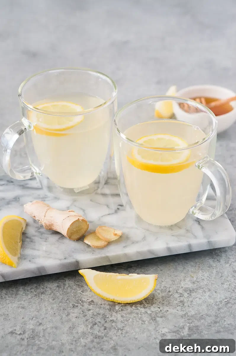 cups with lemon and ginger tea on a board