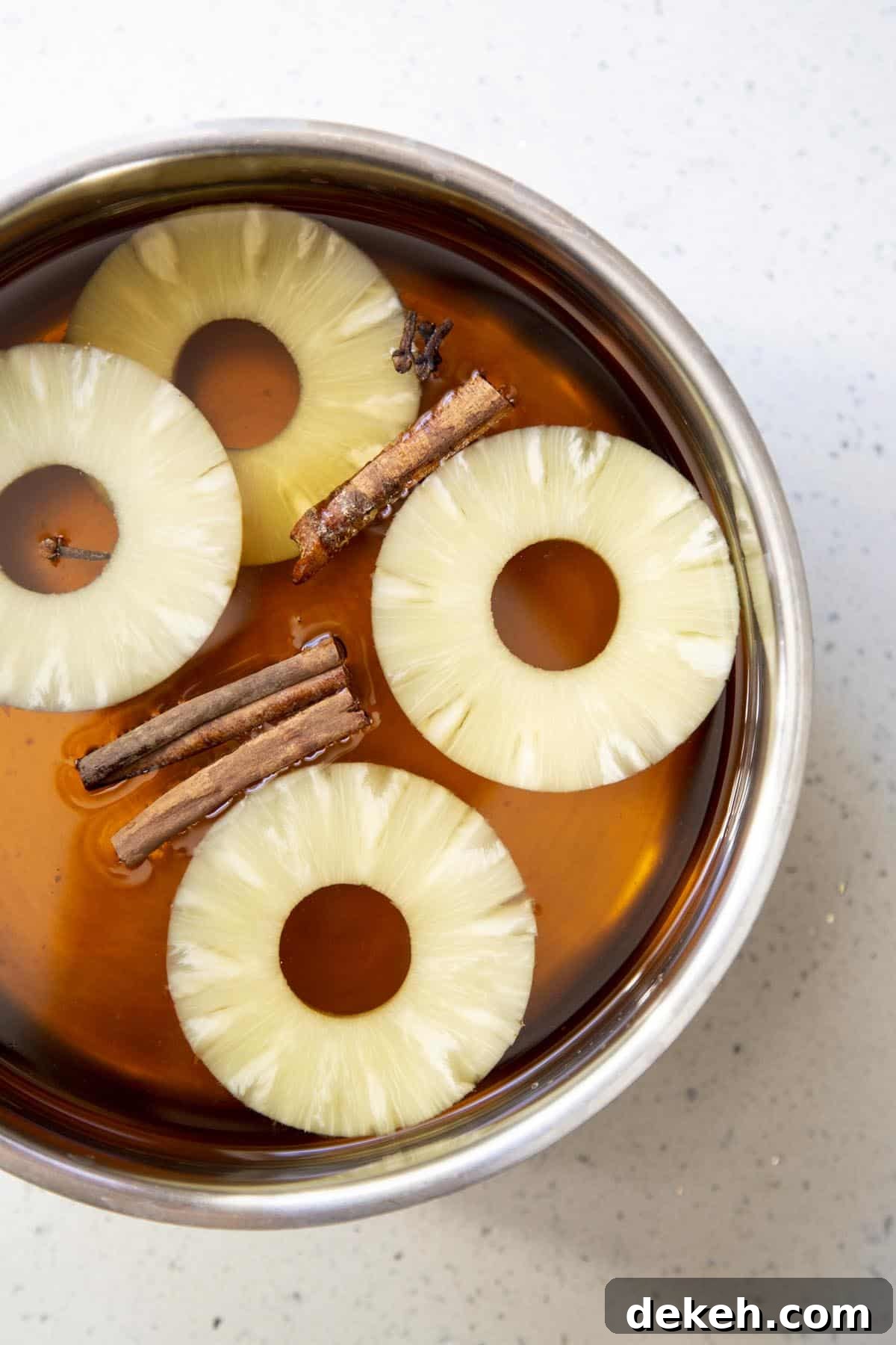 All ingredients for hot spiced apple cider in a stainless steel pot.