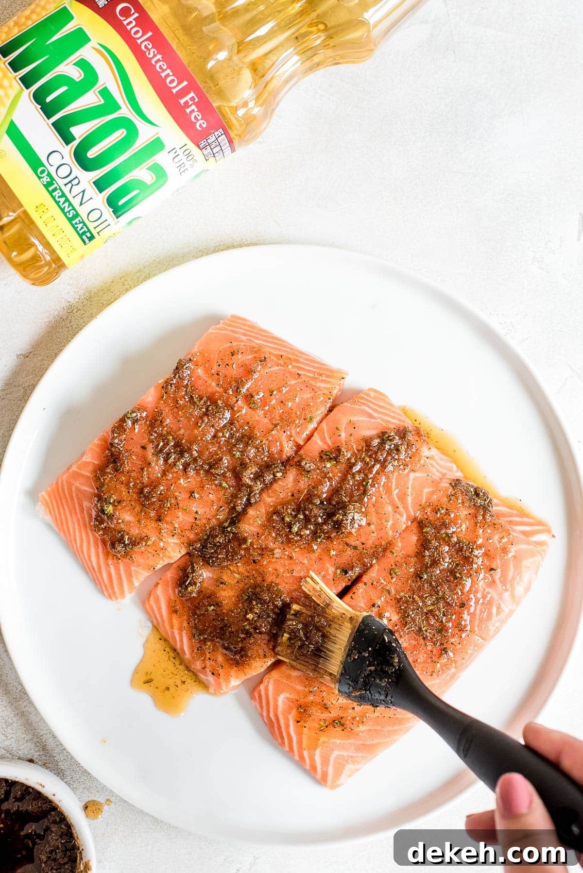 raw salmon being coated in marinade
