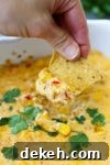 Hot Corn Dip Recipe-close up of taking a chip into the cheesy dip
