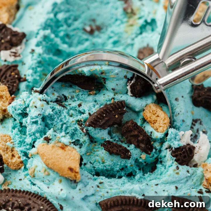 closeup view of a pan of homemade cookie monster ice cream, being scooped with a metal ice cream scoop
