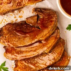 Sliced up beef brisket cooked in the slow cooker with gravy over the top, ready to serve.