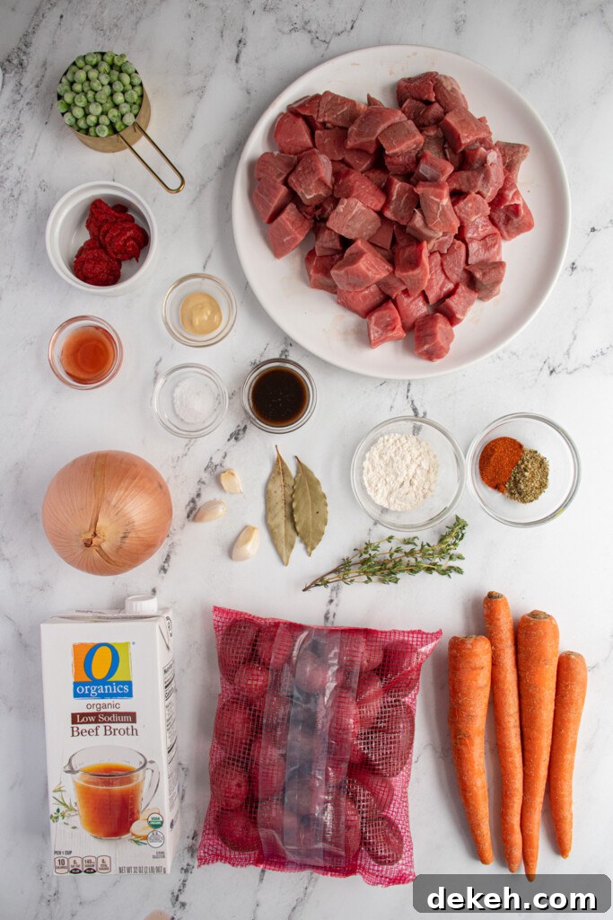 Overhead view of a tabletop filled with the ingredients needed to make slow cooker beef stew.