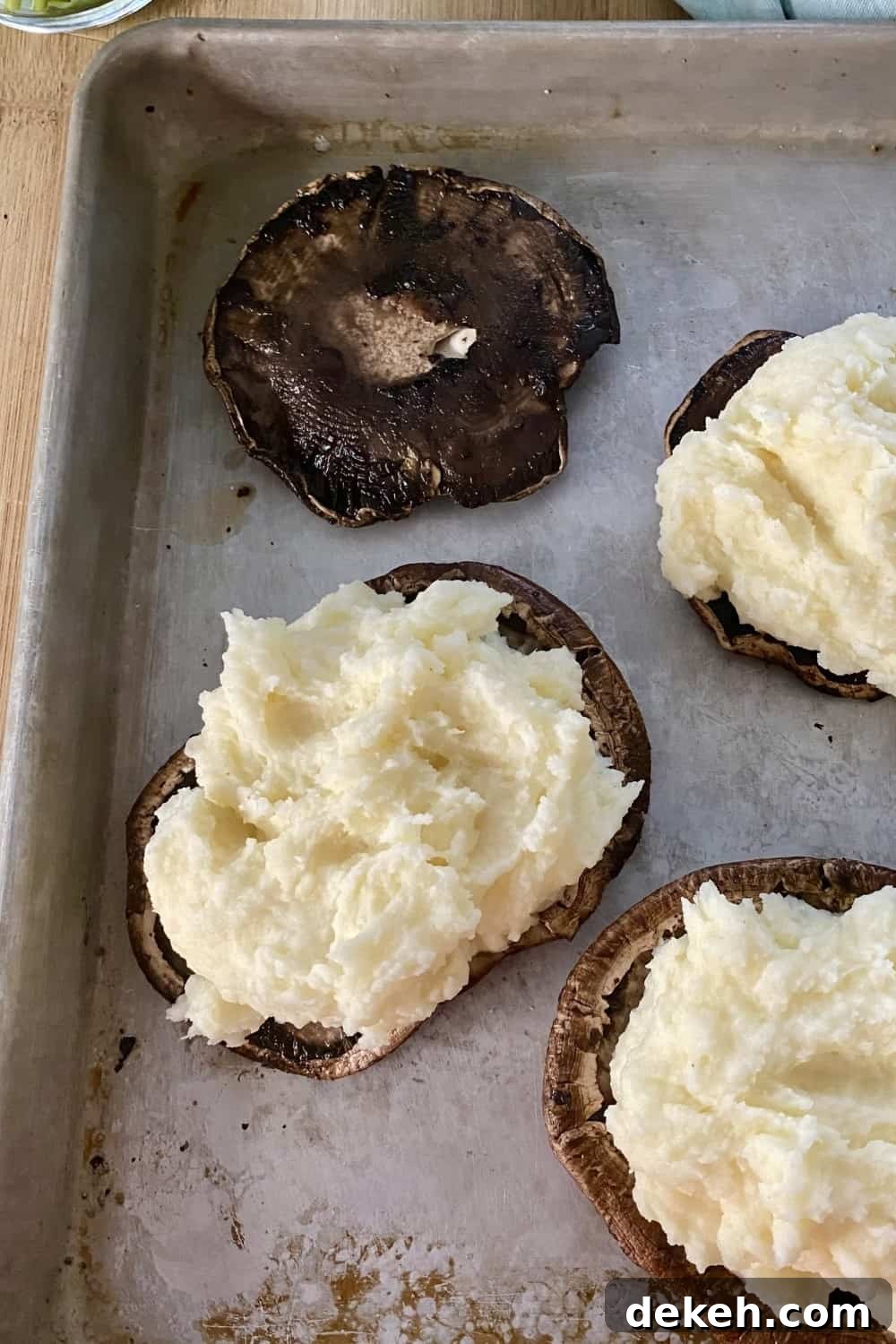 Stuffing roasted mushroom caps with mashed potatoes.