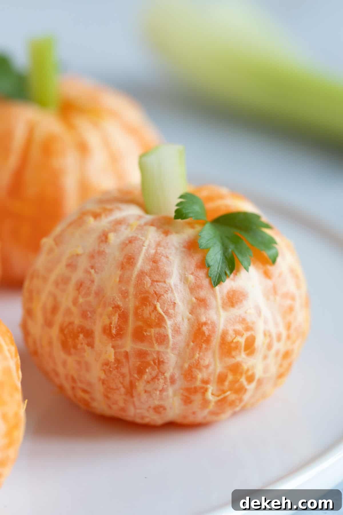 A Halloween clementine pumpkin on a plate.